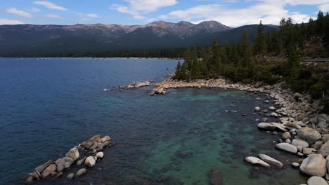 Imágenes-De-Drones-Aéreos-De-4k-Sobre-La-Costa-Rocosa-Del-Lago-Tahoe,-Agua-Azul-Clara-Con-Montañas-De-Sierra-Nevada-En-El-Norte-De-California