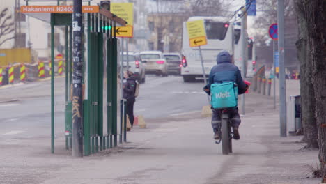 Ciclista-Entregando-Comida-A-Los-Clientes-Pedales-En-La-Acera-De-La-Ciudad-De-Helsinki