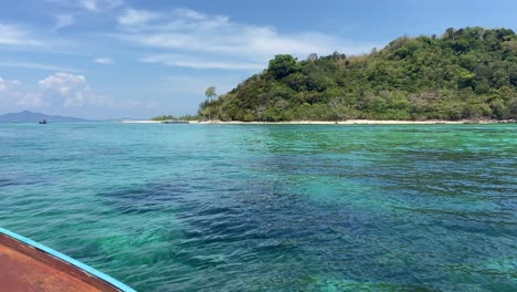 Arriving-at-an-bamboo-tropical-island-in-a-long-tail-boat-on-a-sunny-day,-Thailand