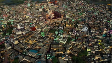 Camera-is-moving-from-above-towards-side-A-small-temple-is-also-visible-and-many-different-residential-buildings-are-visible-in-the-building-and-many-cars-are-also-visible