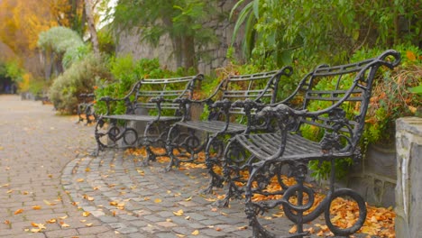 Three-old-metal-benches-are-available-to-walkers-in-a-neighborhood-of-Dublin,-Ireland