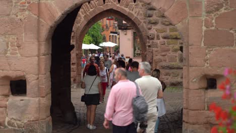 People-Walks-Past-Fortified-gateway-to-the-town-which-has-a-25-meter-high-belfry-offering-a-bellicose-face-to-the-outside-and-a-benevolent-aspect-inside-the-Riquewihr-village