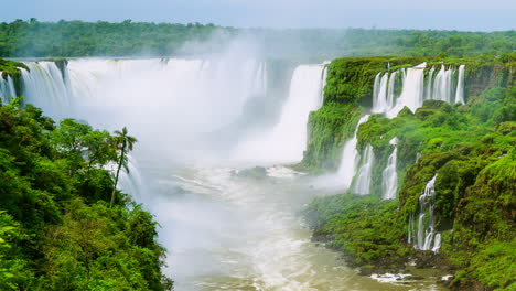 Timelapse-of-Waterfalls-of-Iguazu-around-a-big-green-area-and-a-river,-in-a-sunny-day,-Foz-do-Iguacu,-Parana,-Brazil