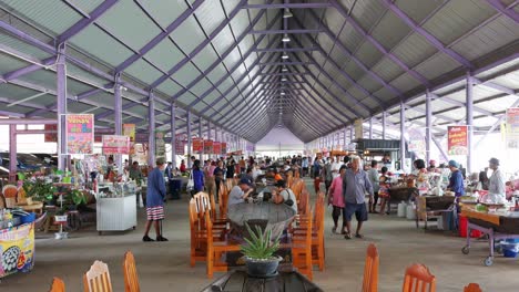 Caminando-Por-Un-Mercado-De-Alimentos-Local,-Los-Residentes-De-Bangkok-Comen-Mientras-Algunos-Todavía-Buscan-Comida-Para-Comprar-Y-Comer-En-Un-Edificio-En-Bangkok,-Tailandia