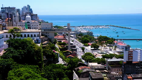 Aerial-view-of-Elevador-Lacerda,-the-neighborhood-around-and-the-sea-at-background,-Salvador,-Bahia,-Brazil