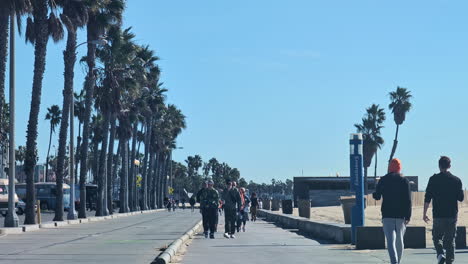 Touristen-Laufen-Mittags-Bei-Grellem-Sonnenlicht-Auf-Dem-Bürgersteig-In-Venice-Beach