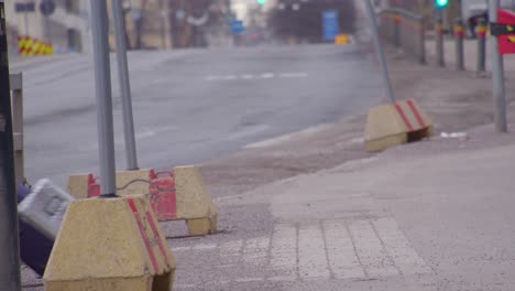 Pedestrians-with-rolling-luggage-cross-street-in-Helsinki,-Finland