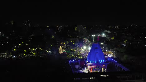 Aerial-drone-view-phone-camera-is-flying-behind-the-temple-and-many-houses-are-visible-with-light-Sony-lights-and-many-residence-buildings-are-also-there