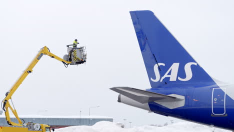 La-Tripulación-De-Tierra-Del-Aeropuerto-Descongela-La-Cola-Del-Avión-Sas-Antes-Del-Vuelo