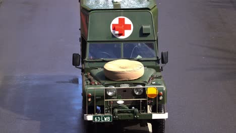 Close-up-shot-of-a-vintage-military-medical-vehicle-driving-down-the-street,-participating-the-annual-Anzac-Day-parade-tradition,-Brisbane-city,-Queensland,-Australia