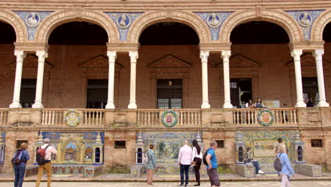 Plaza-de-España,-Seville,-Spain---Tourists-Delighting-in-and-Snapping-Photos-of-the-Balcony-Adorned-with-Arches-and-Columns---Static-Shot