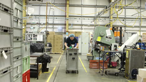 warehouse-established-with-worker-walking-inside-a-factory-with-a-Toolbox-trolley