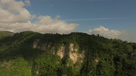 Drone-descending-point-of-view-of-Muchas-Aguas-mountains,-San-Cristobal-in-Dominican-Republic