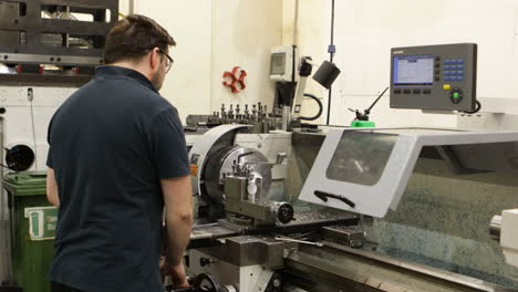 Factory-worker-operating-CNC-milling-machine-with,-side-view