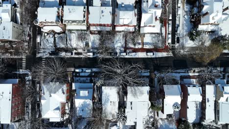 Vogelperspektive-Einer-Schneebedeckten-Straße,-Gesäumt-Von-Häusern-Und-Kahlen-Bäumen