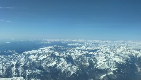 Pilot-POV-flying-over-The-snowed-Apls-mountains-at-10000m-high,-shot-from-a-jet-cockpit
