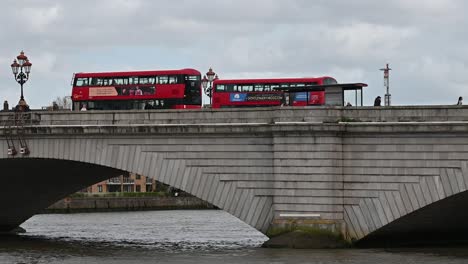 Buses-driving-overPutney-Bridge,-London,-United-Kingdom