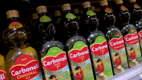 Botellas-De-La-Marca-De-Cocina-Española-Y-Aceite-De-Oliva-Virgen-Extra-Carbonell-Se-Muestran-A-La-Venta-En-Un-Supermercado.