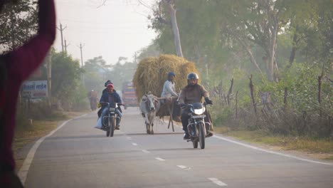 Ein-Ochsenkarren-Und-Sein-Besitzer-Auf-Einer-Dorfstraße-Mit-Motorrädern-Und-Dorffrauen-In-Zentralindien