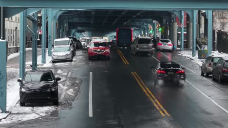 Amazon-delivery-truck-driving-under-SEPTA-train-overpass-in-Kensington,-Philadelphia-on-snowy-winter-day