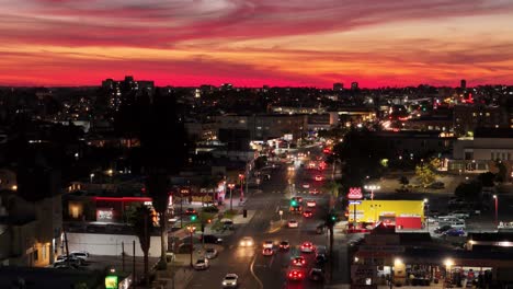 Luftrückflug-Nach-Westen-Mit-Einem-Purpurroten-Himmel-über-Dem-Talmadge-Abschnitt-Des-El-Cajon-Boulevard-In-San-Diego,-Wobei-Der-Verkehr-In-Beide-Richtungen-In-Der-Abenddämmerung-Kurz-Nach-Sonnenuntergang-Fließt