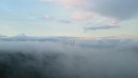 Turbinas-Eólicas-En-Las-Montañas,-Generan-Energía-Verde,-Rodeadas-De-Nubes-En-El-Cielo