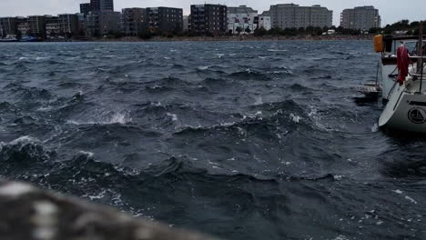 Wavy-Water-Of-Oresund-Strait-With-Limhamn-Island-In-The-Background-From-Limhamns-hamnomrade-In-Malmo,-Sweden