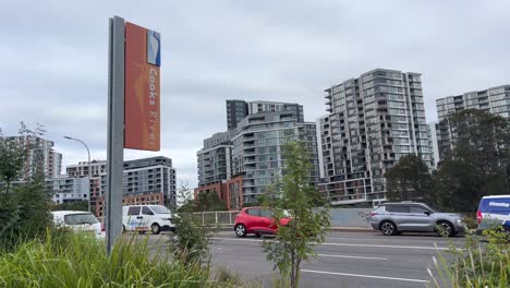 Cooks-River-signage-and-bridge-at-Princess-Highway-with-residential-neighbourhood-apartments-in-the-background