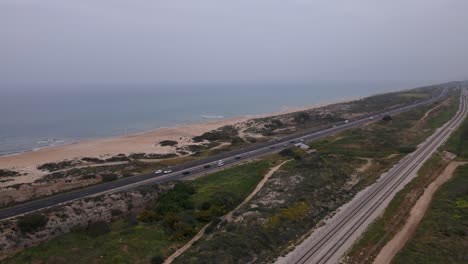 Megadim-Moshav,-Israel---Cars-Journeying-on-the-Coastal-Highway-Adjacent-to-the-Mediterranean-Shoreline---Aerial-Drone-Shot