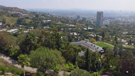 Toma-Aérea-De-Drones-De-Las-Fincas-De-West-Hollywood-Y-Trousdale-En-Los-Ángeles,-Piscinas-Y-Patios-Traseros-Con-Condominios-Y-Edificios-En-El-Horizonte.