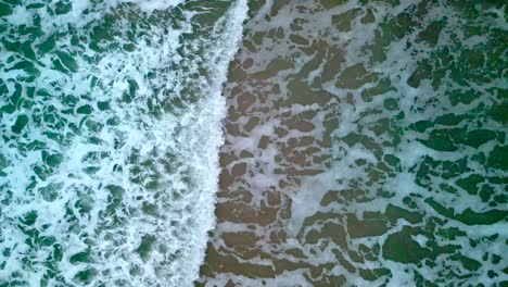 Static-aerial-shot,-produced-in-4K-60-frames-per-second-showing-waves-as-they-crash-together