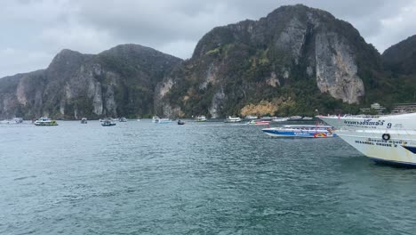 Traffic-of-boats-in-Phi-Phi-islands-under-cloudy-sky,-Thailand