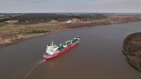 Freighter-cruising-on-the-bend-of-a-river---aerial-view