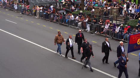 Representatives-from-the-108-Field-Battery-walking-down-the-street-of-Brisbane-city,-participating-in-the-annual-Anzac-Day-parade-with-cheering-crowds-lined-the-street