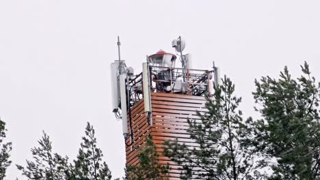 A-tall-telecommucitations-tower-sea-signal-tower,-lighthouse-with-a-red-roof-and-a-green-light-on-top