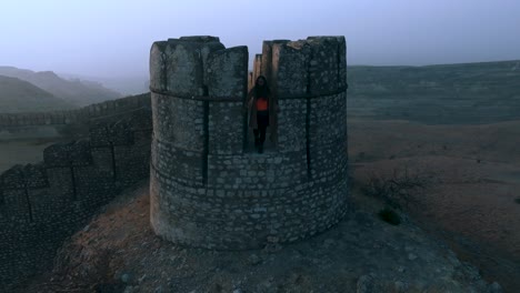 Drohnenansicht-Eines-Touristenmädchens,-Das-Auf-Der-Festung-Ranikot-In-Sindh,-Pakistan-Steht