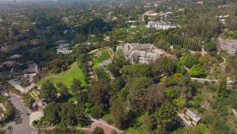 Drone-Shot-Approaching-Beautiful-Historic-Greystone-Mansion-in-Beverly-Hills-California-on-Sunny-Day,-Gorgeous-Estate-As-Seen-From-Above