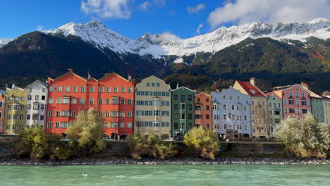 October-November-autumn-fall-Innsbruck-Austria-colorful-pastel-buildings-capital-Tyrol-Tyrolean-Alps-mountain-backdrop-the-bridge-over-the-Inn-River-Innbrücke-clear-blue-sky-clouds-static-shot
