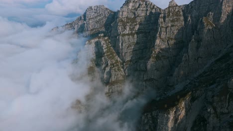 Cinematic-view-of-Resegone-mountain-top-shrouded-in-fog-on-cloudy-day-under-peaks-in-northern-Italy