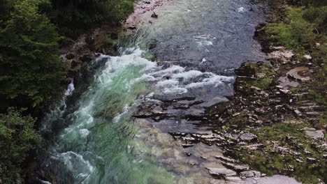 Wilder-Fluss-Mit-Kleinem-Wasserfall-Und-Kristallklarem-Wasser,-Drohnenflug