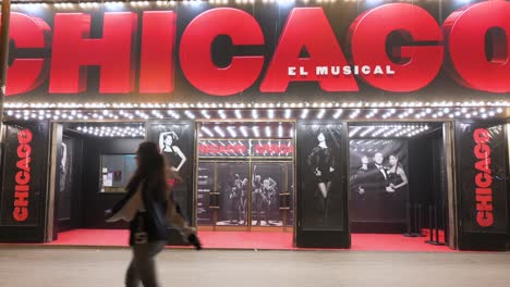 Pedestrians-walk-past-the-Apolo-Theater,-currently-featuring-the-musical-hit-original-Broadway-production,-Chicago,-in-Spain