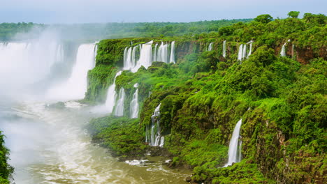 Timelapse-of-Waterfalls-of-Iguazu-around-a-big-green-area-and-a-river,-in-a-sunny-day,-Foz-do-Iguacu,-Parana,-Brazil