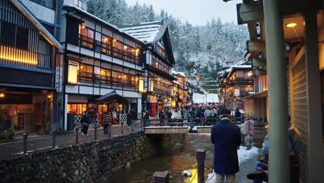 Slow-motion-pan-establishing-shot-of-traditional-onsen-town-with-snowy-roofs