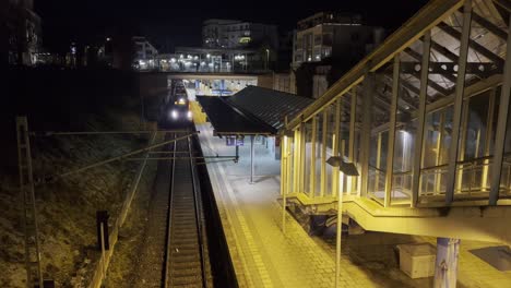 Metro-train-entering-the-station-of-Echterdingen-near-Stuttgart-at-nighttime