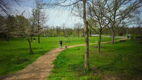 Zeitraffer-Im-Noorderpark-Amsterdam-Im-Frühling-Mit-Familien,-Die-über-Den-Weg-Laufen