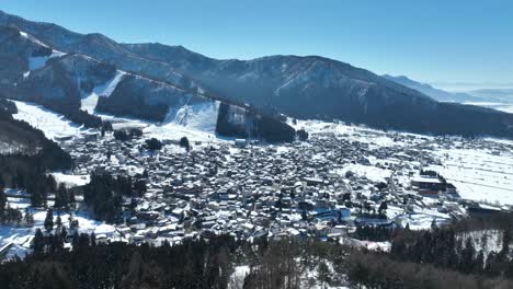 Aerial-drone-pull-away-shot-of-Japans-Nozawaonsen-Mountain-Ski-Resort-Village