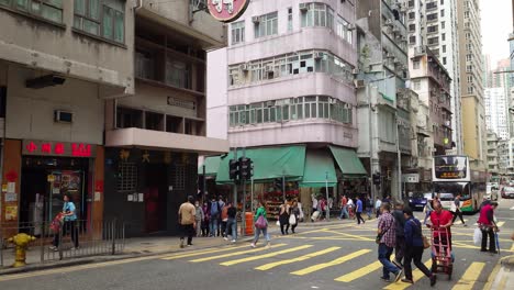 Imagen-Inclinada-Hacia-Abajo-De-Personas-Cruzando-La-Calle-De-Kennedy-Town-En-Hong-Kong-Bajo-Un-Día-Nublado