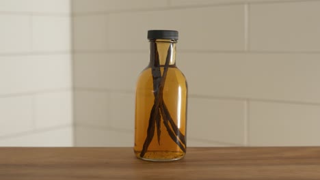 Hand-setting-down-bottle-of-homemade-vanilla-extract