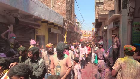 pov-shot-Many-people-are-going-on-the-way-to-the-temple-and-many-people-are-blowing-different-kinds-of-colors-and-also-blowing-water-from-pichkari