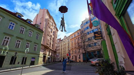 Mujer-Tomando-Fotografías-De-Una-Escultura-De-Ligera-Incertidumbre,-Un-Hombre-Con-Paraguas-Colgando-En-Praga,-República-Checa